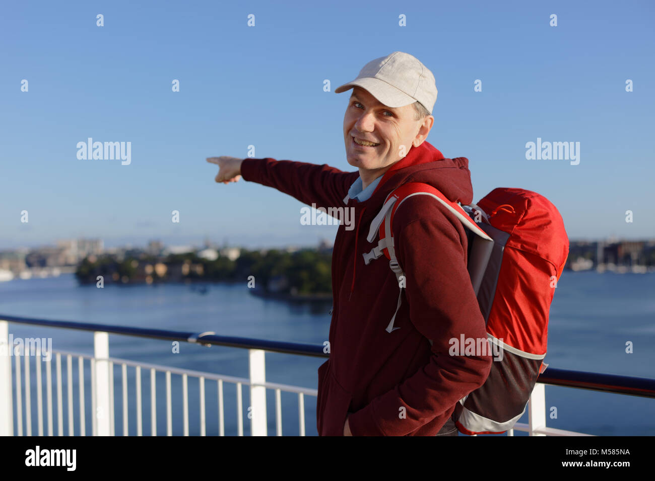 Tourist with backpack on a deck of cruise ship Stock Photo