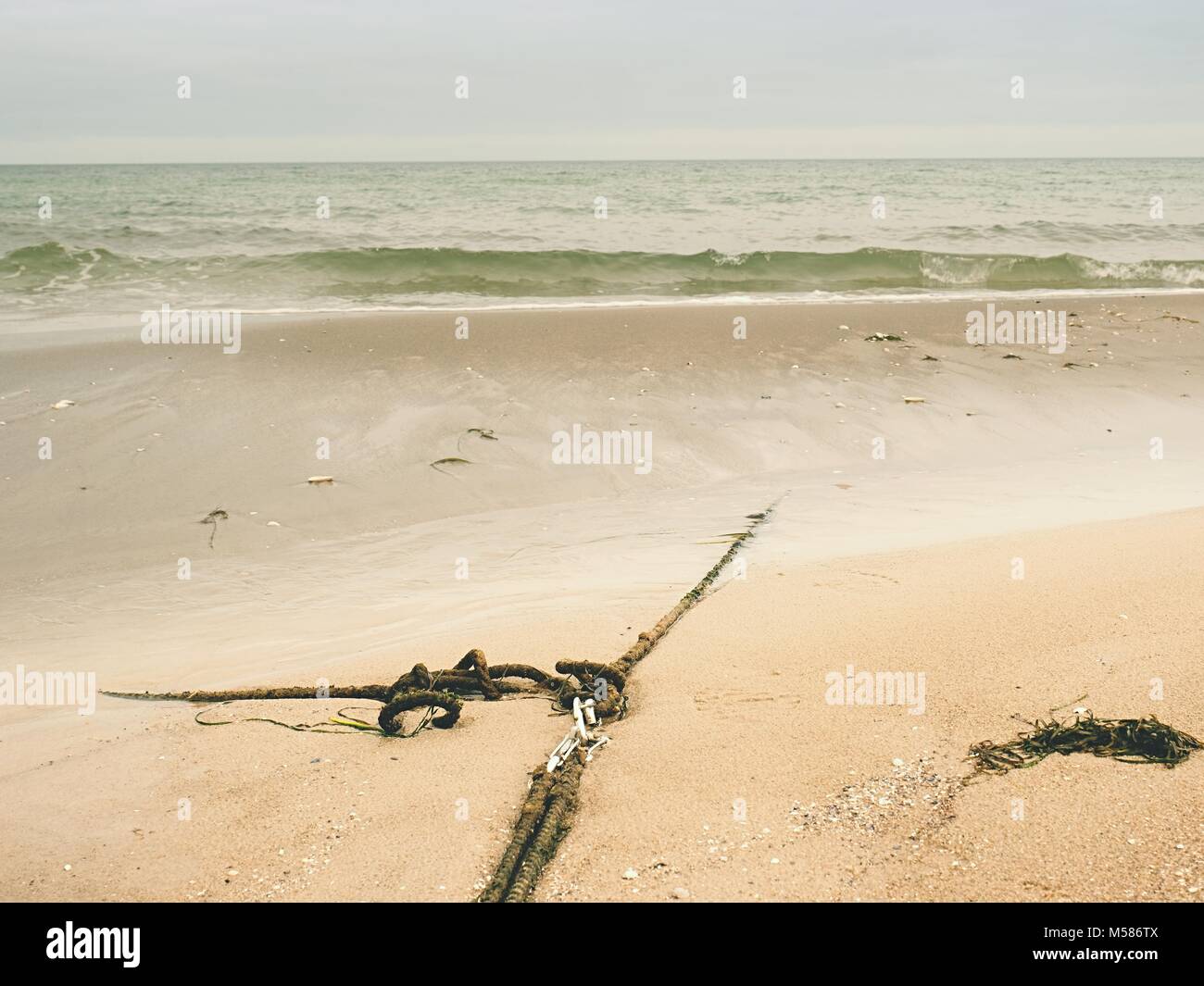 Ship old anchor rope with snap hook and line under sea. Steel shackle