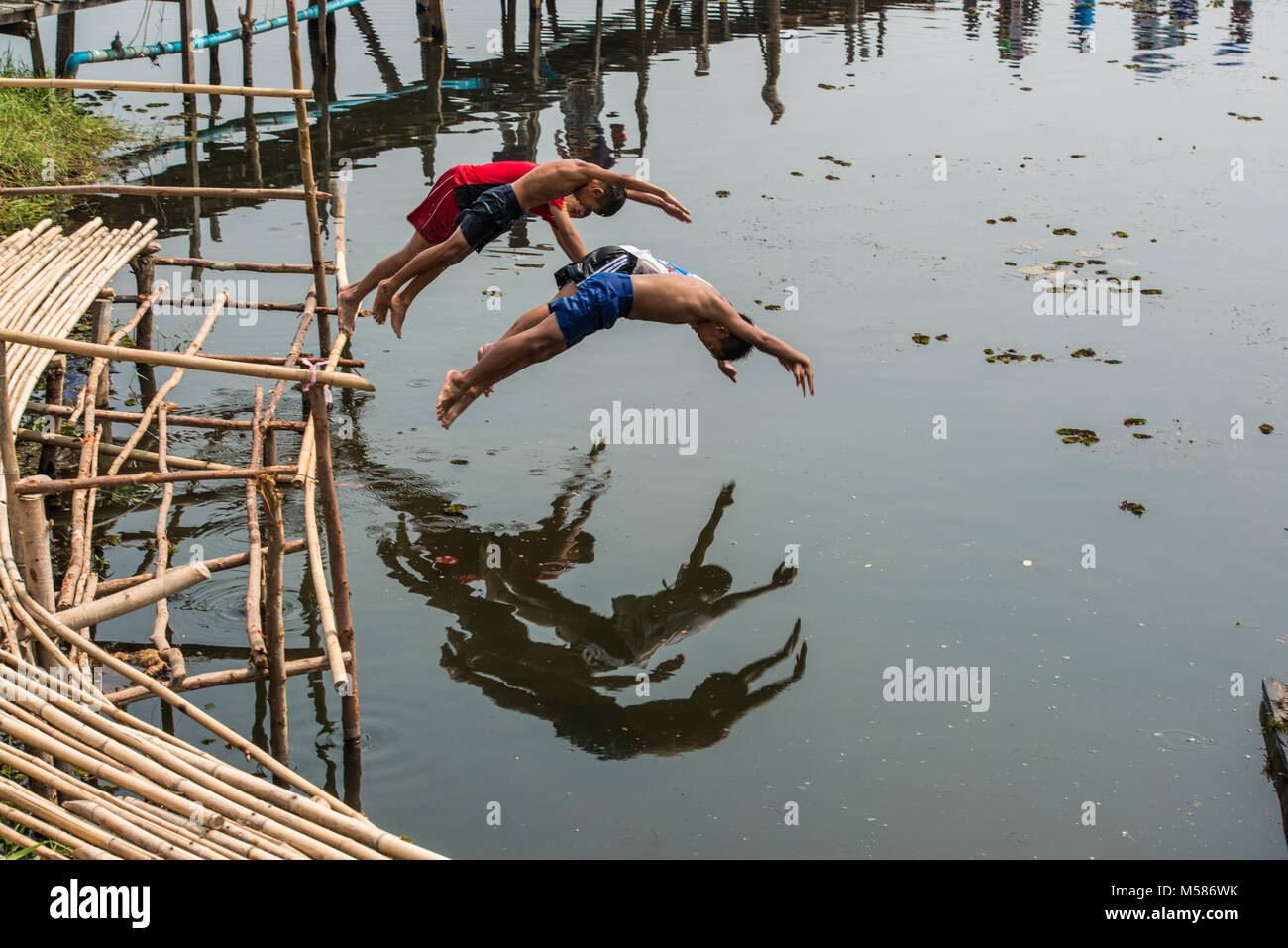 Mahasarakham, Thailand - February 22, 2016: Rural children lifestyle having fun by jumping  into river together in Mahasarakham, Thailand. Stock Photo