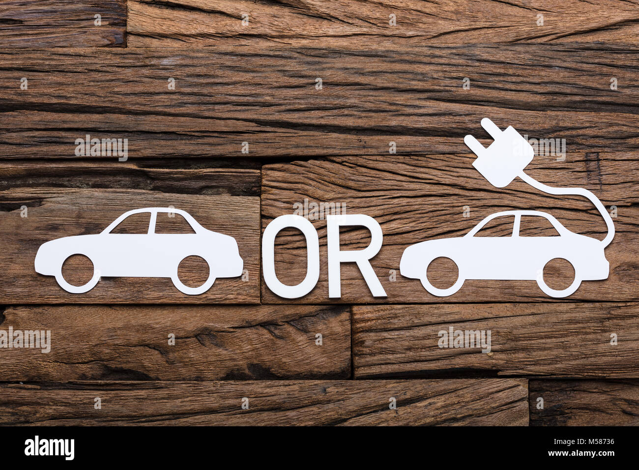 Directly above shot of auto and electric paper cars with OR sign on wooden table Stock Photo