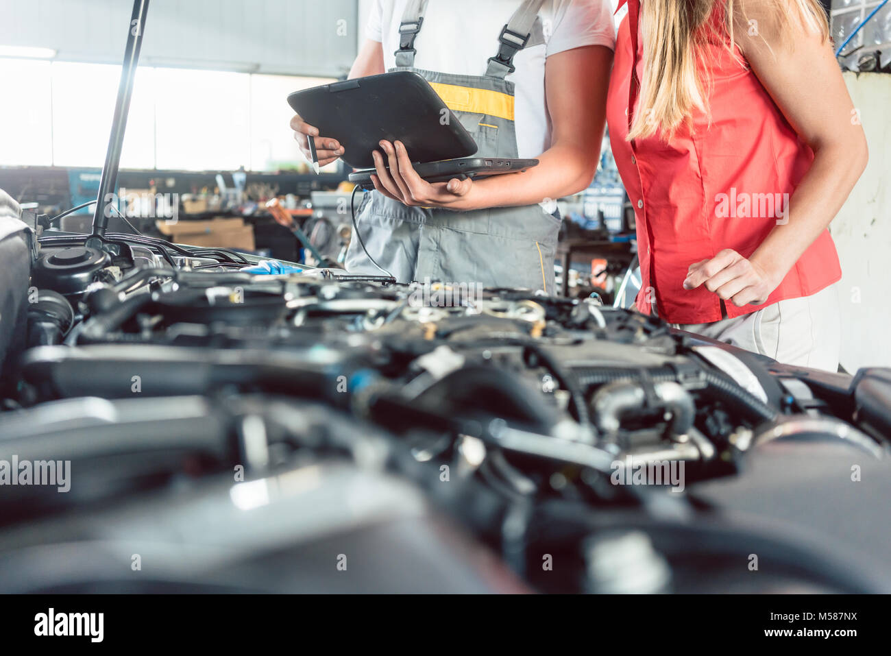 Closeup of the hand of an auto mechanic opening the oil reservoir