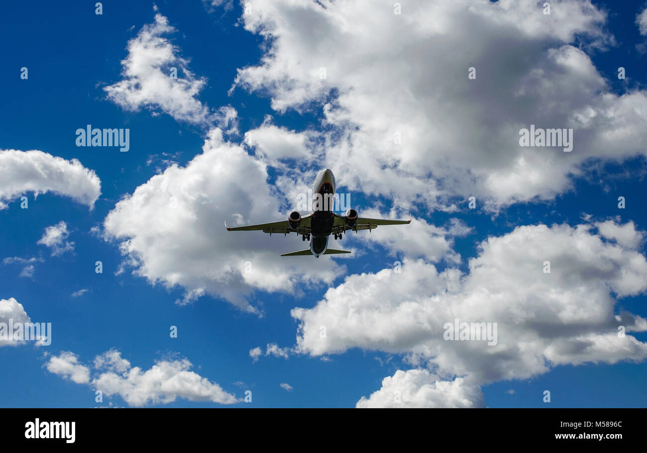 The plane on a background of blue sky and white clouds Stock Photo - Alamy
