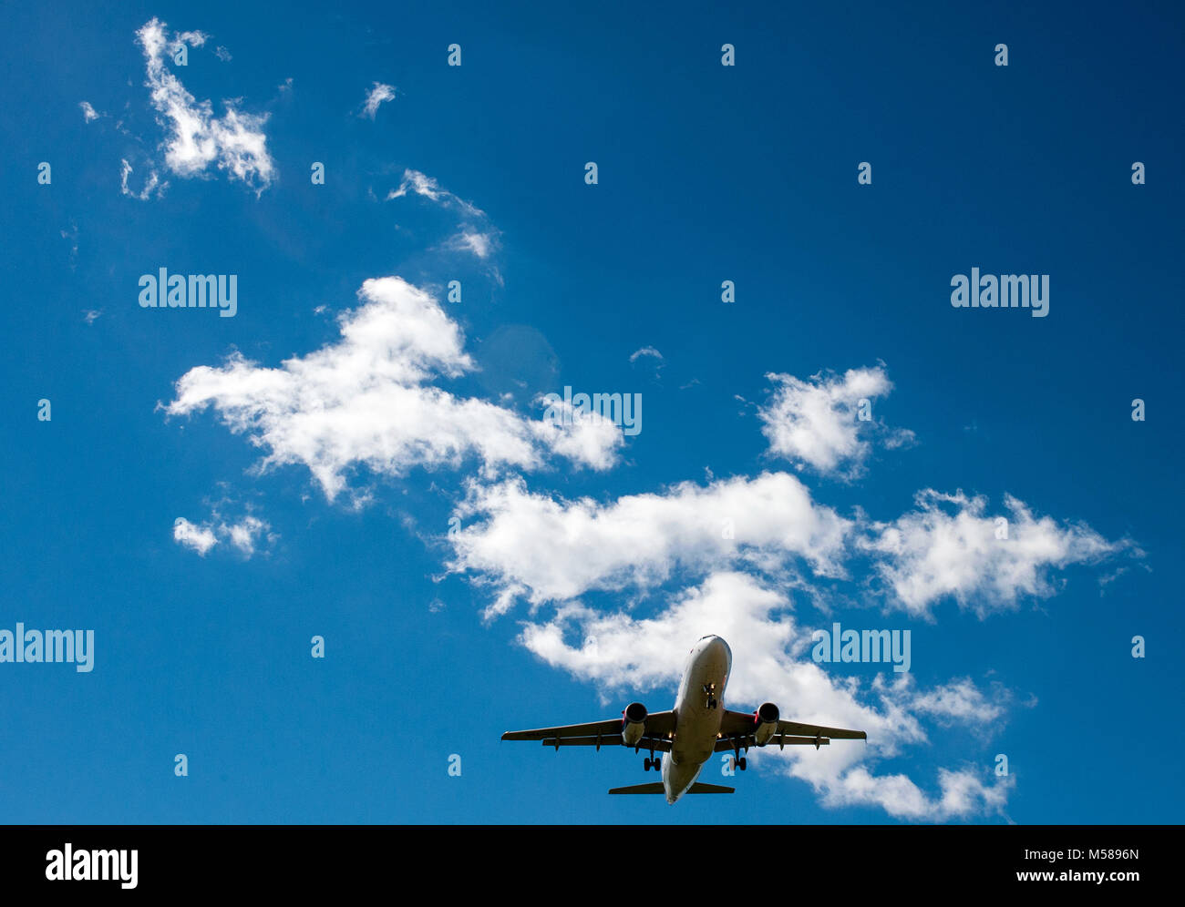 The plane on a background of blue sky and white clouds Stock Photo - Alamy