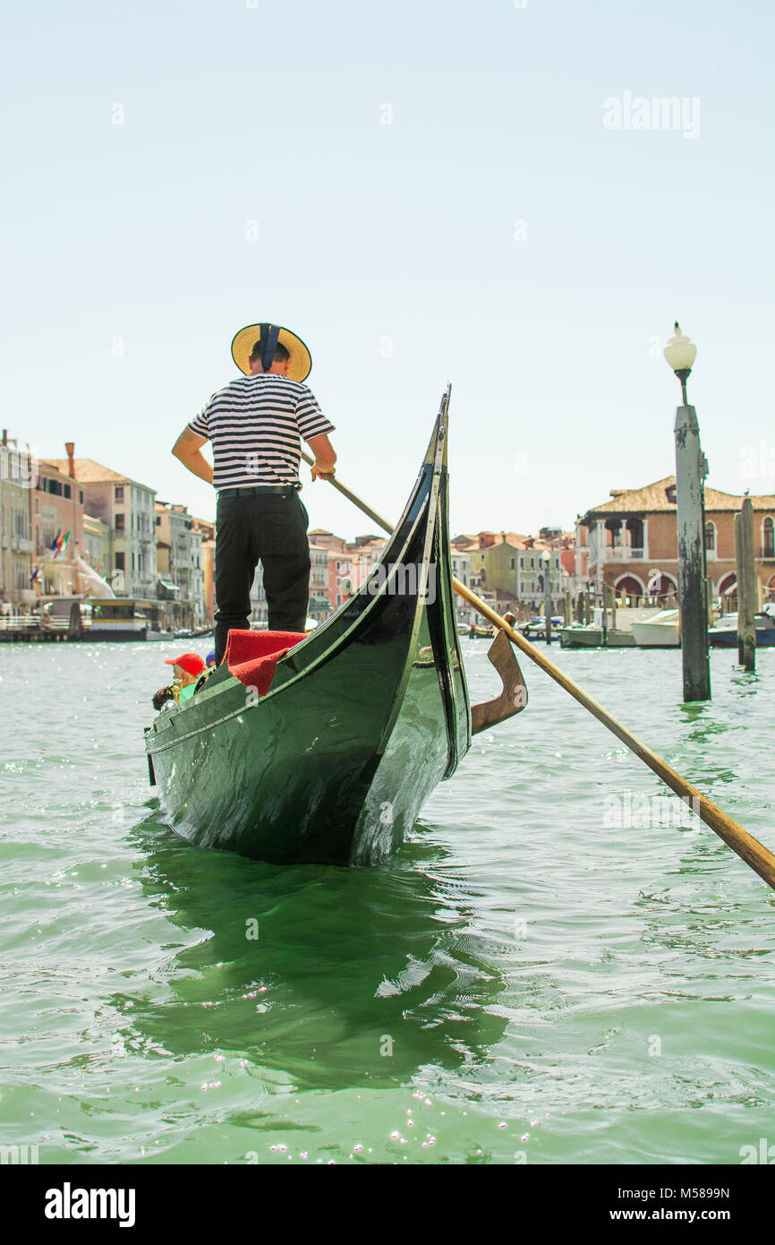A singing gondola driver whistling on the gorgeous Grande Canal in Venice, Italy, Europe near rialto bridge Stock Photo