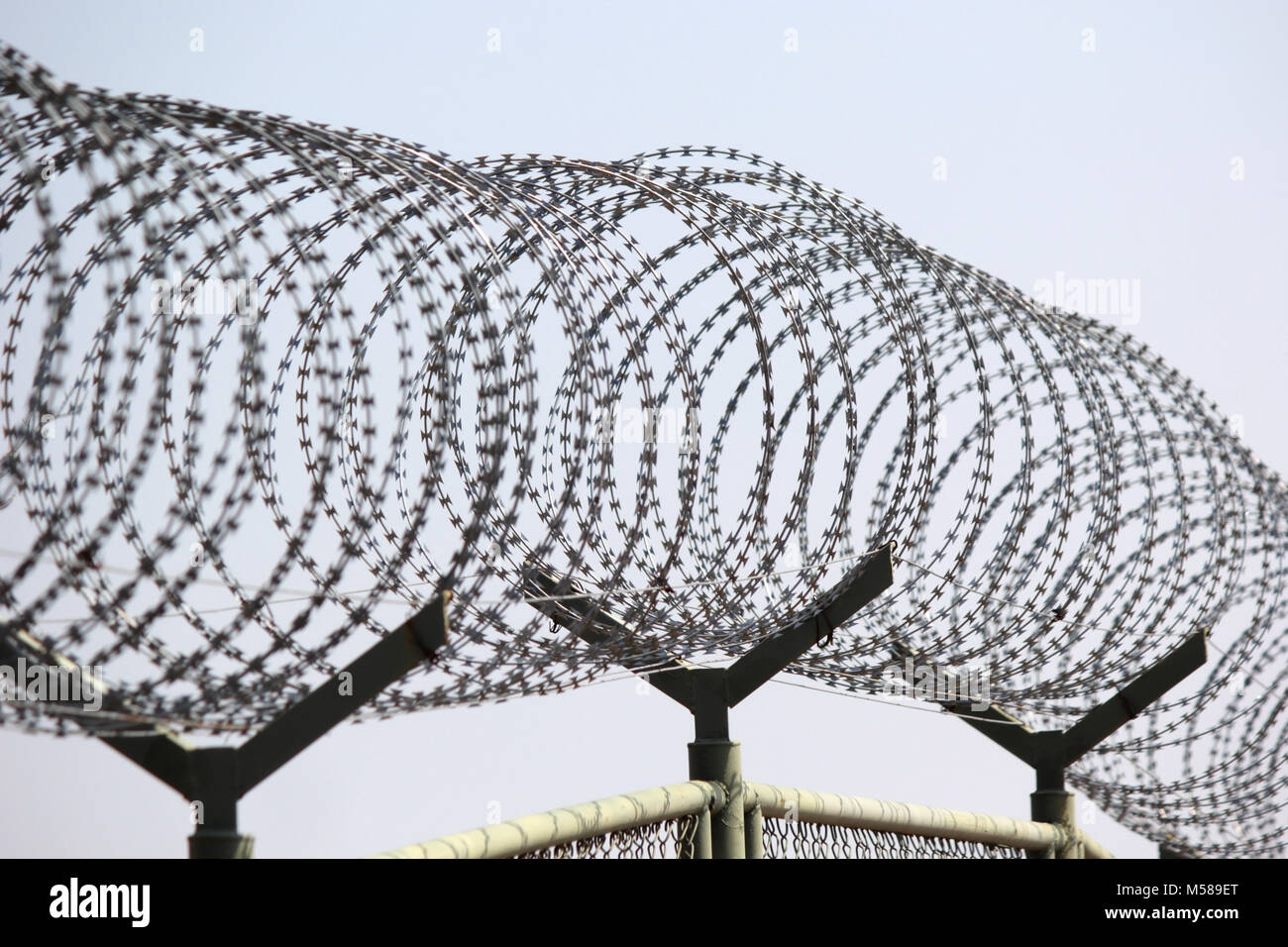 wire fence with barbed wires with sky background Stock Photo - Alamy