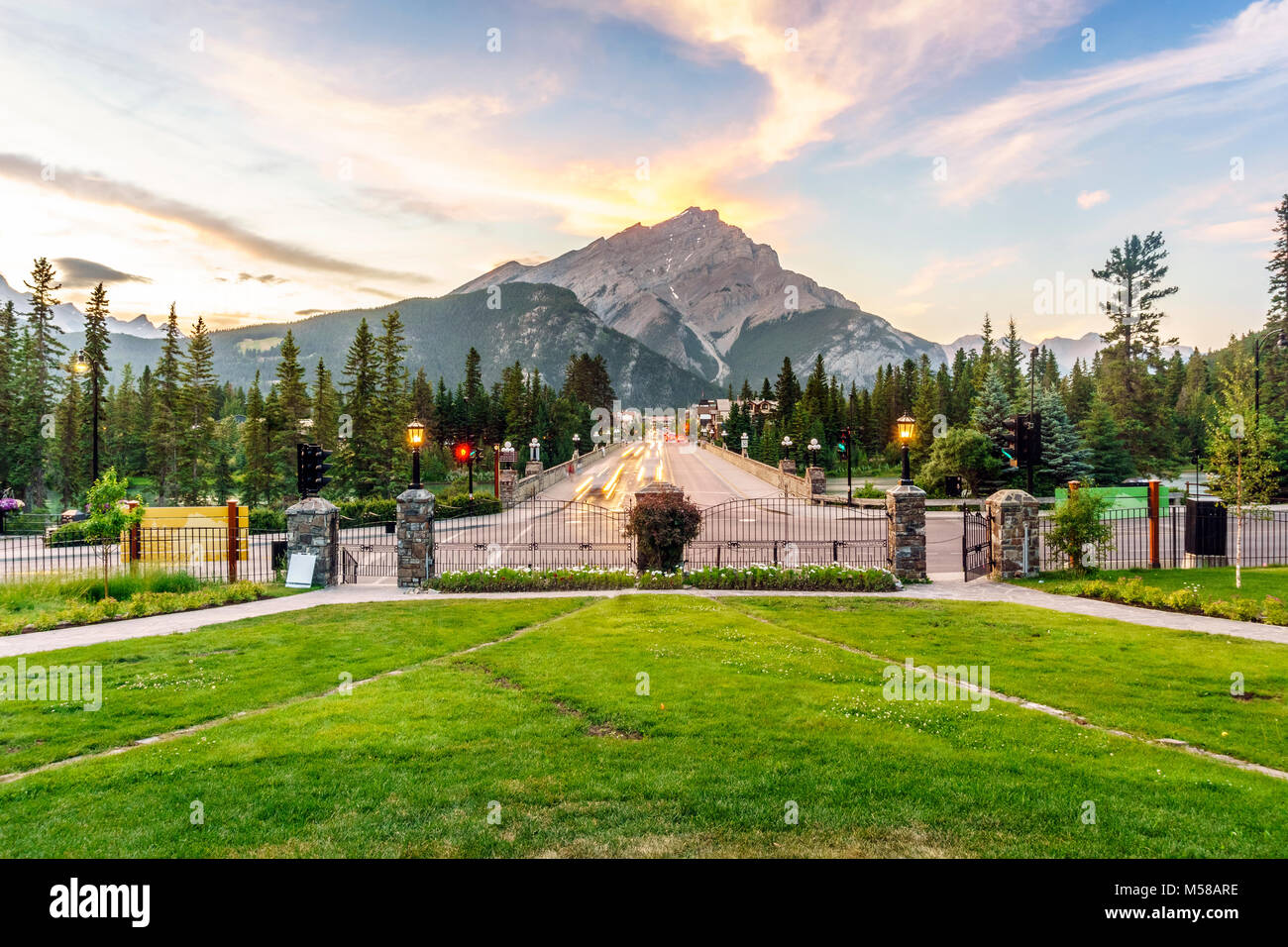 Main street in Banff with Cascade Mountain towering over town at sunset, Alberta, Canada Stock Photo