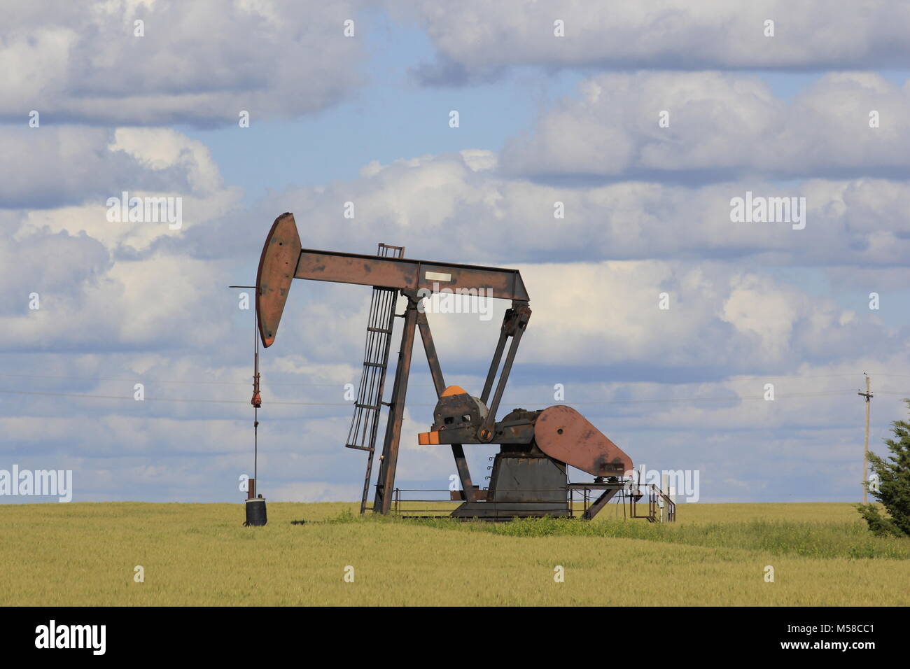 Kansas Oil Well Pump with white Clouds Stock Photo