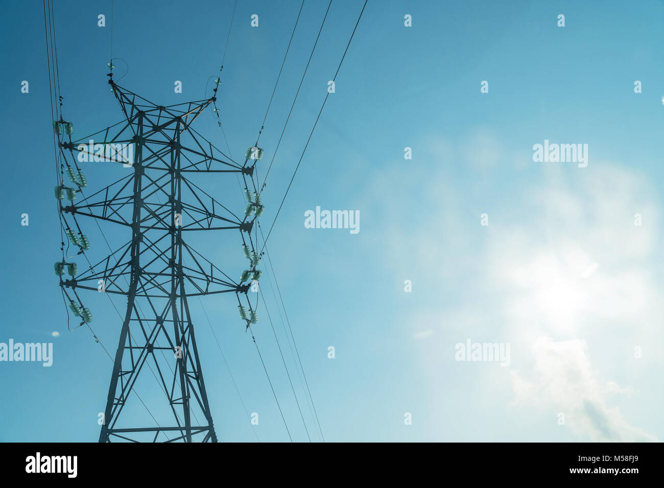 High voltage power line tower on a blue sky background Stock Photo - Alamy