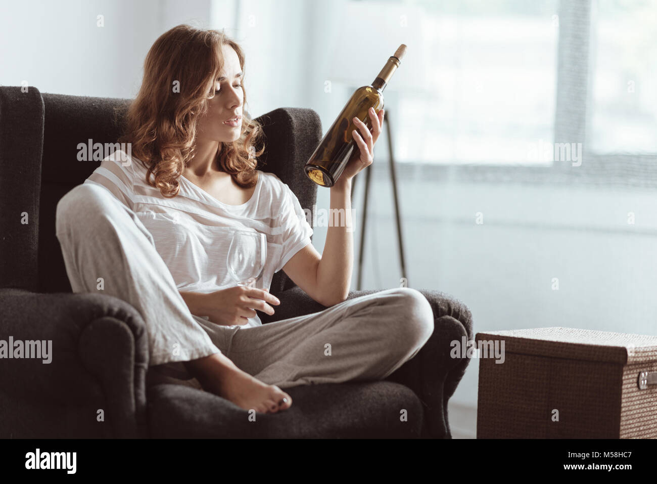 Depressed woman drinking wine at home Stock Photo