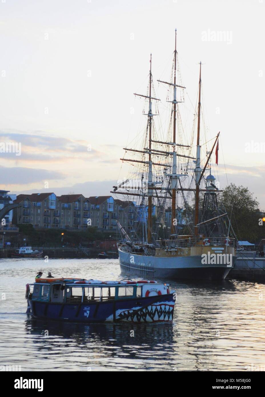 Harbour ferry 'No 7' passing barque 'Kaskelot', built by J. Ring-Andersen in 1948, moored at Hannover Quay, Bristol Harbour, UK. Stock Photo