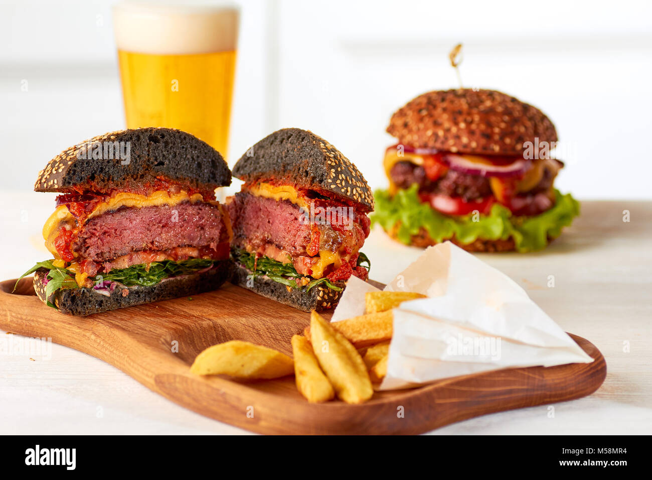 Sliced juicy burger with chips and beer Stock Photo