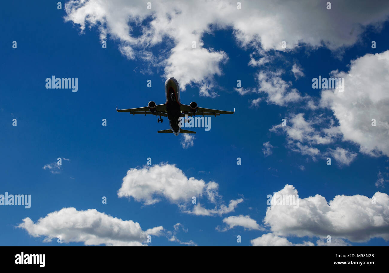 The plane on a background of blue sky and white clouds Stock Photo - Alamy