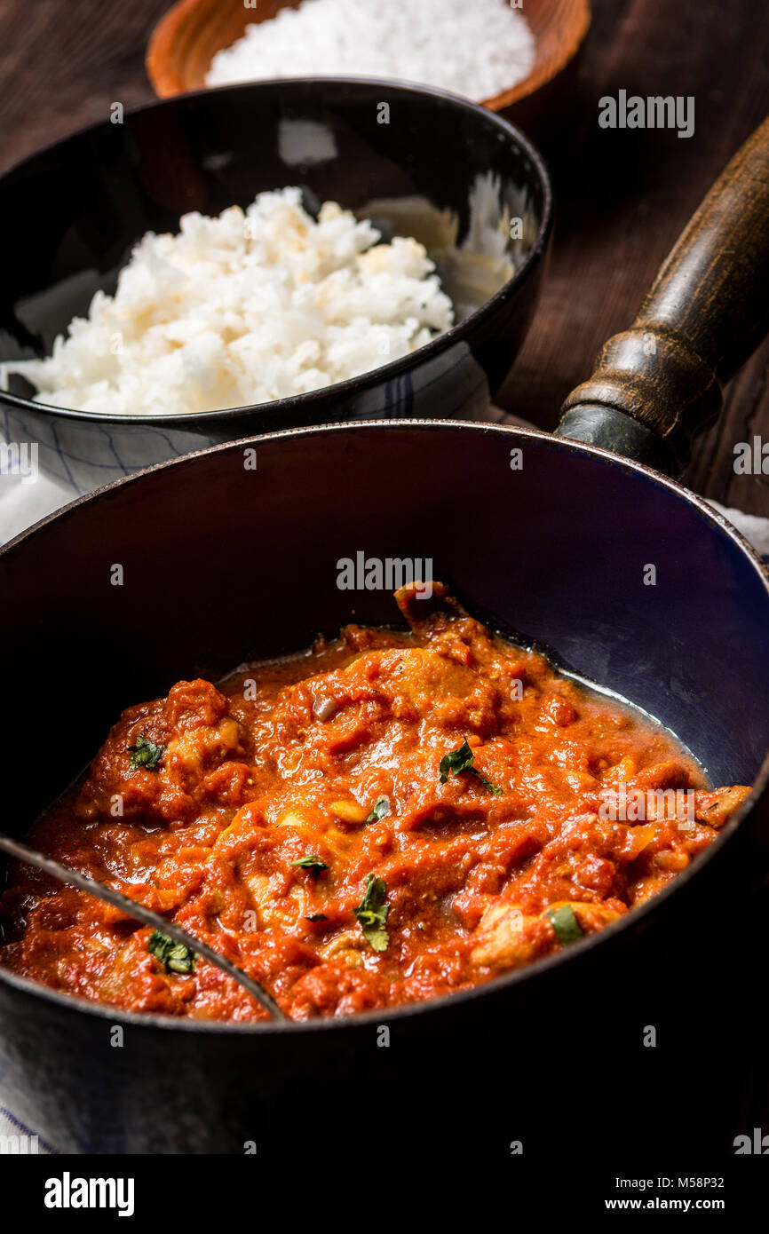 Traditional indian cuisine. Spicy tikka masala with rice on wood table Stock Photo