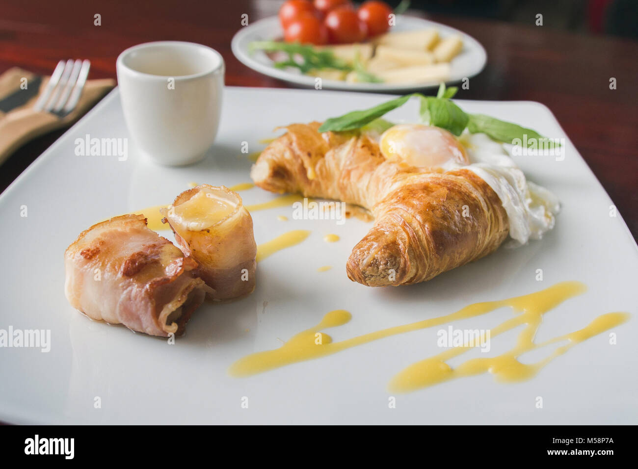 Fried eggs with bacon on white plate - breakfast in restaurant, selective focus Stock Photo