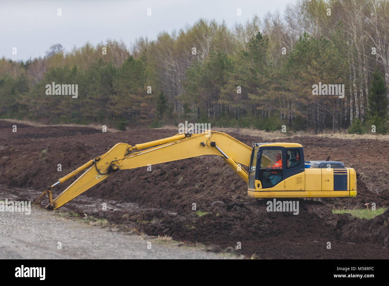 Road construction - Yellow excavator at work Stock Photo - Alamy