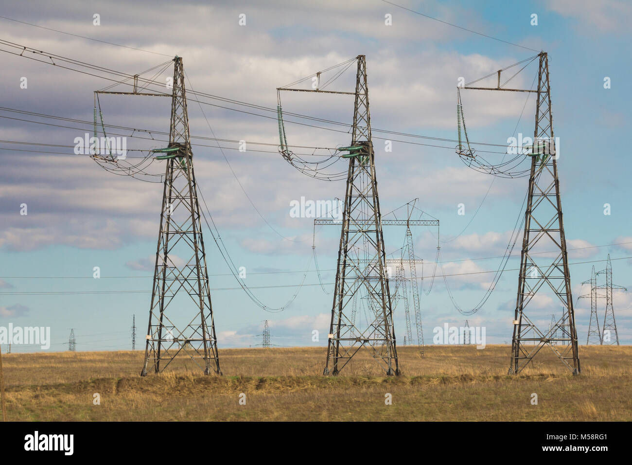 Electricity pylons and lines at summer field, sunny day Stock Photo - Alamy
