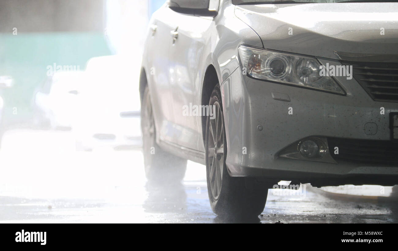 Washing a car in the suds by water hoses Stock Photo Alamy