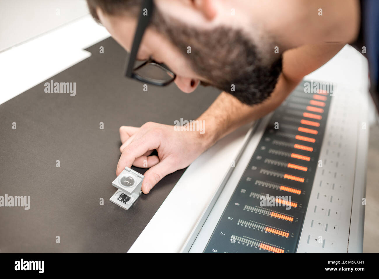 Checking the quality of the printing with magnifying glass Stock Photo