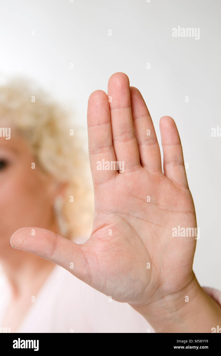 Head And Shoulder View Of An Unrecognizable Blond Woman In Front Of White Background With Palm Outstretched Against The Camera Stock Photo Alamy