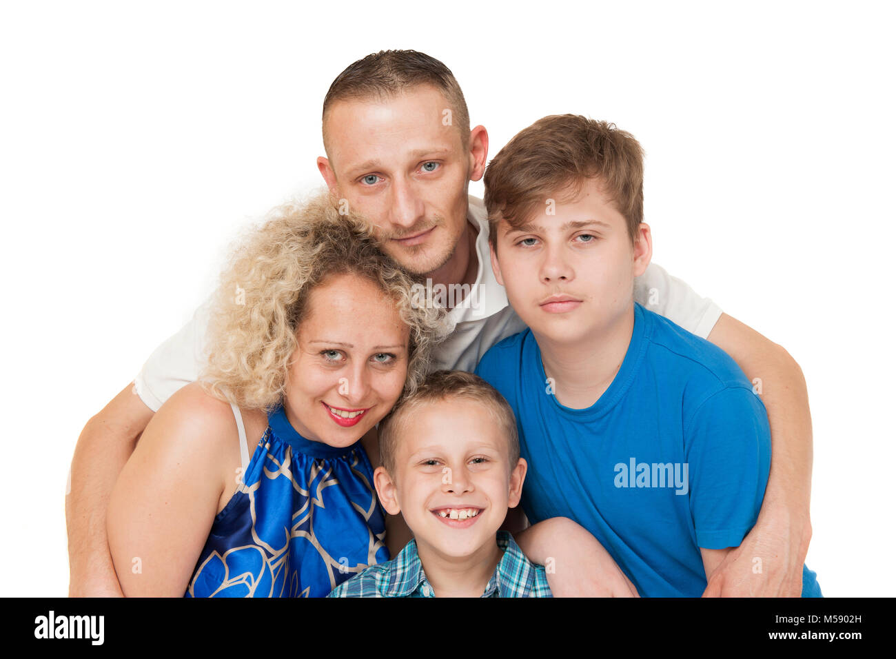 Head and shoulders portraits of a young family with father, mother and two boys against white background. Father puts his arms around his family. Stock Photo