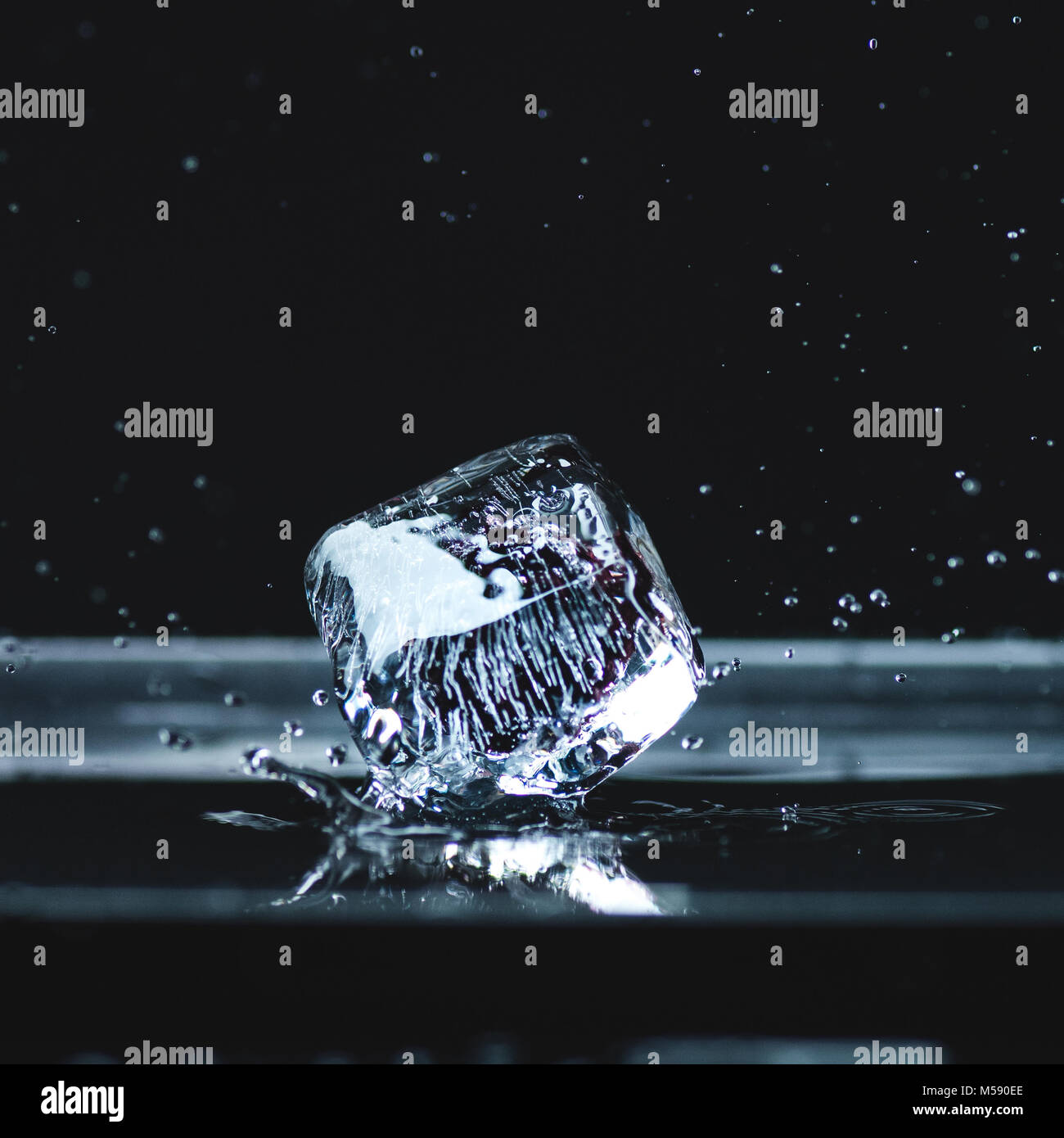 melting ice cube with water drops Stock Photo - Alamy