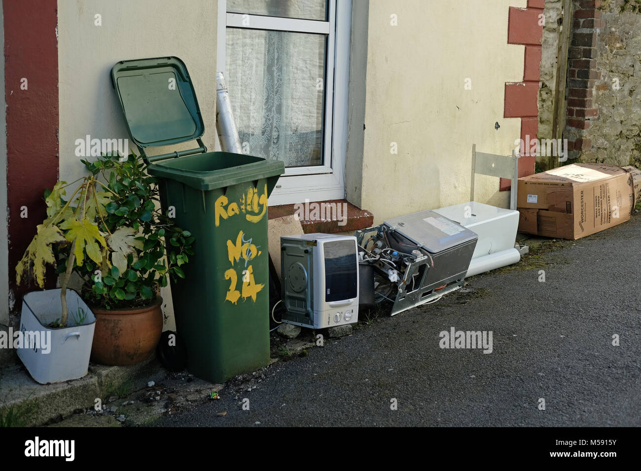 Electrical goods dumped outside a house. Stock Photo