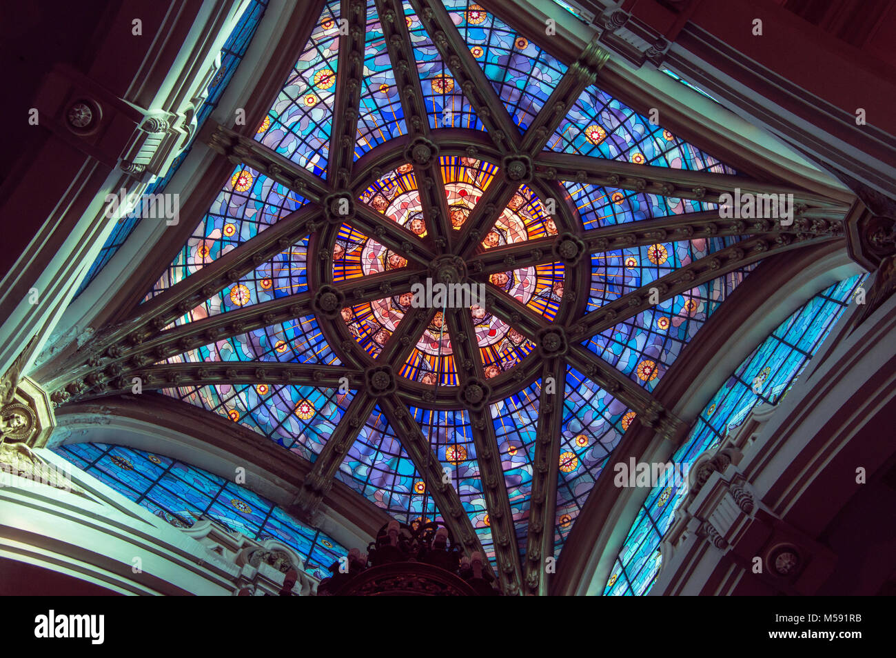 Dome seen from eclectic style inside of blue and orange crystals in the church of Our Lady of Silence in Madrid. Spain. Stock Photo