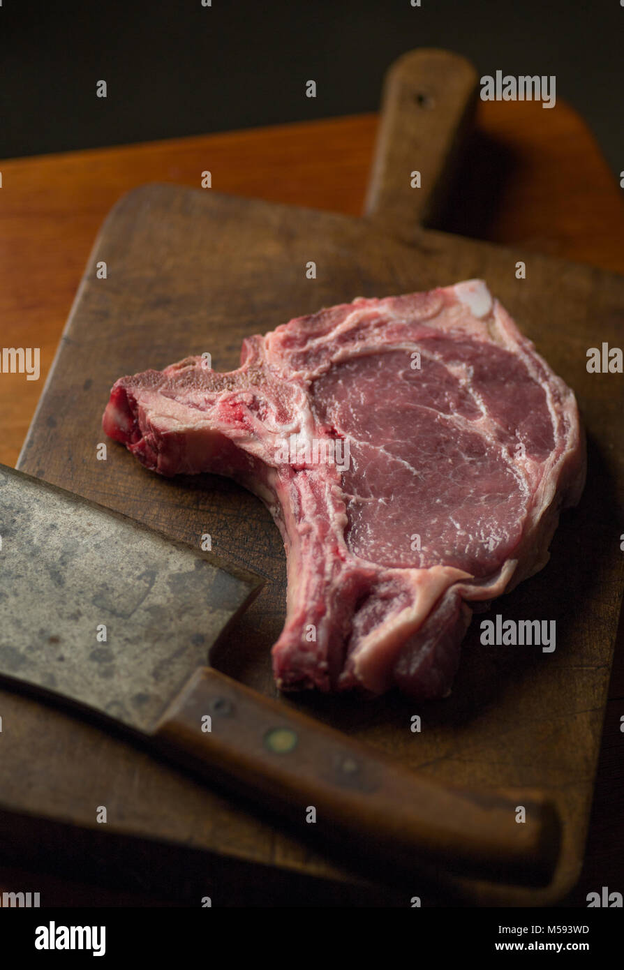 Tbone roast beef steak with a vintage cleaver on a cutting board Stock