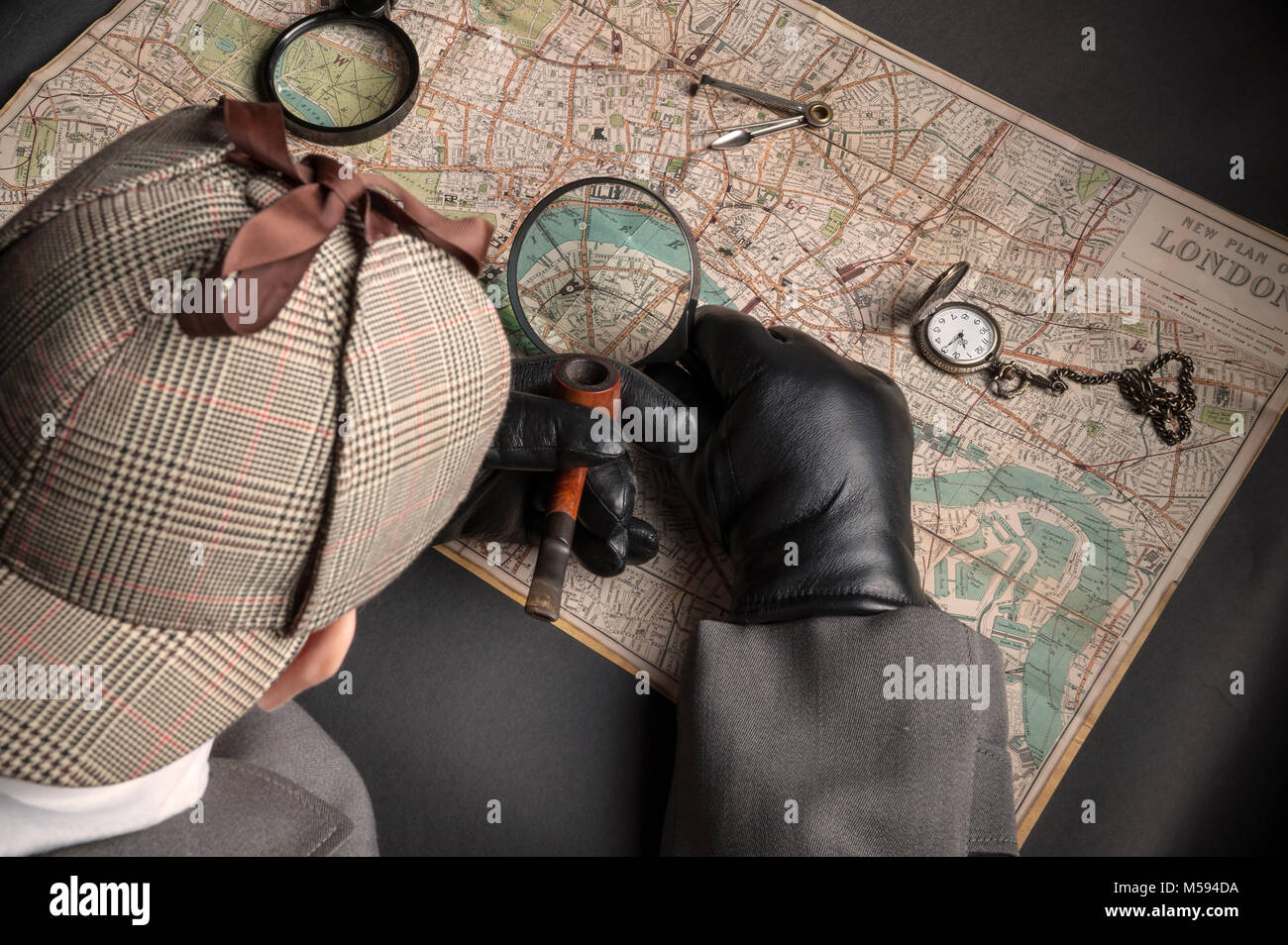 Detective man- magnifying glass, map of London, clock on chain Stock Photo