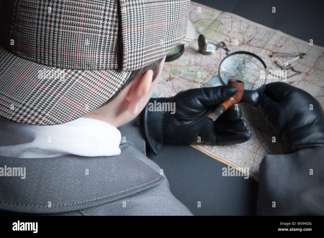 Detective man- magnifying glass, map of London, clock on chain Stock Photo