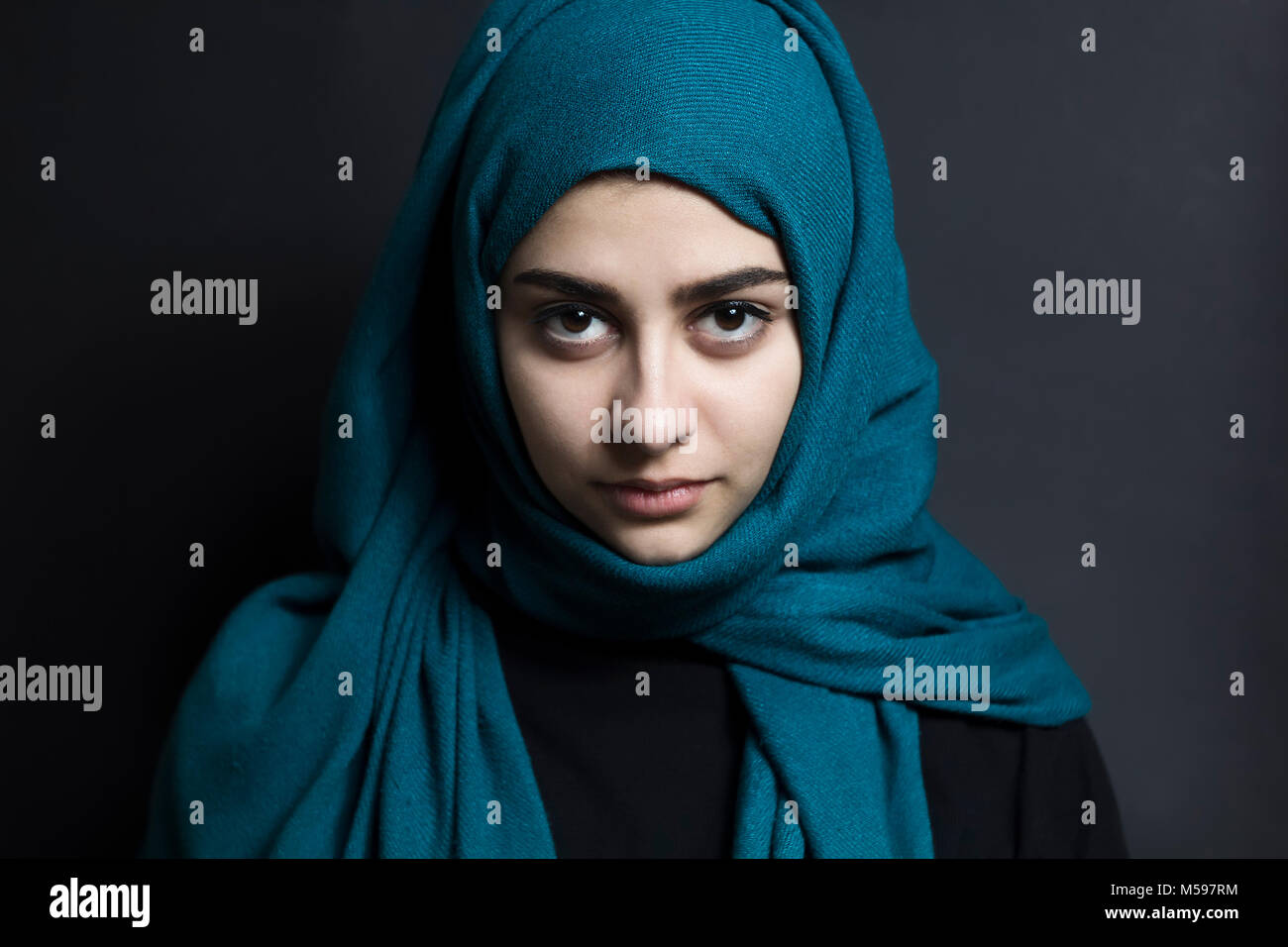 A beautiful Muslim girl with eyes on a black background. Arab woman with beautiful eyes. Stock Photo