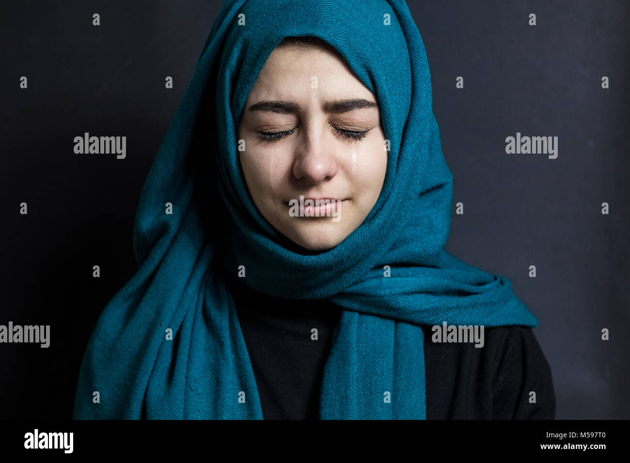 An Arab woman is crying. Portrait of a Muslim girl with tears in her eyes. Stock Photo