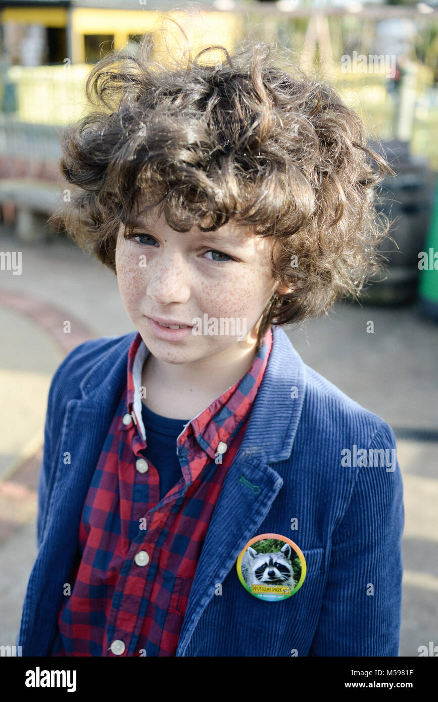 portrait of a curly haired little boy with freckles playing