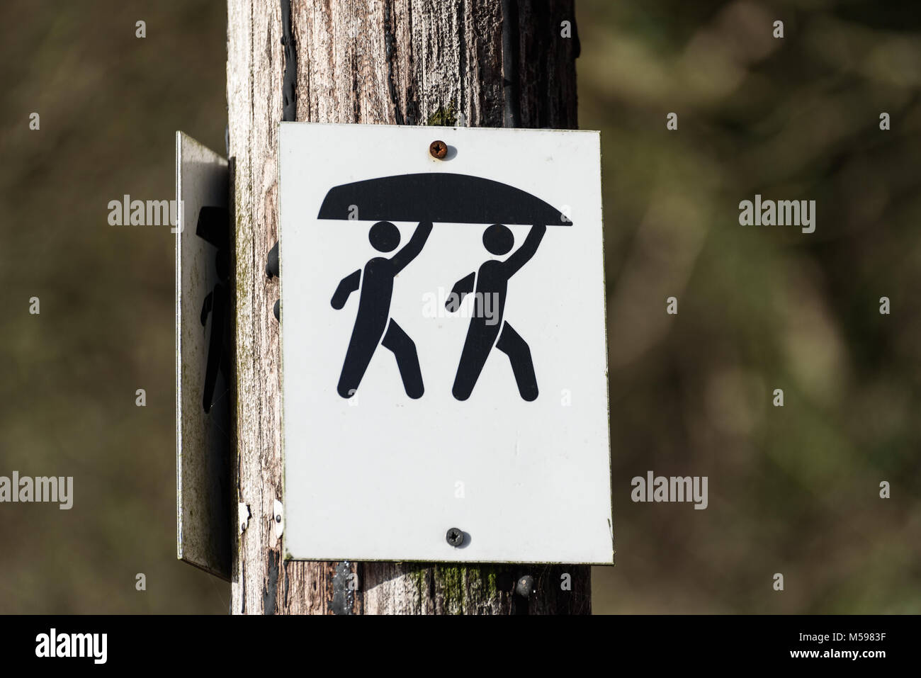 A canoe and Kayak portage sign on a post. Stock Photo