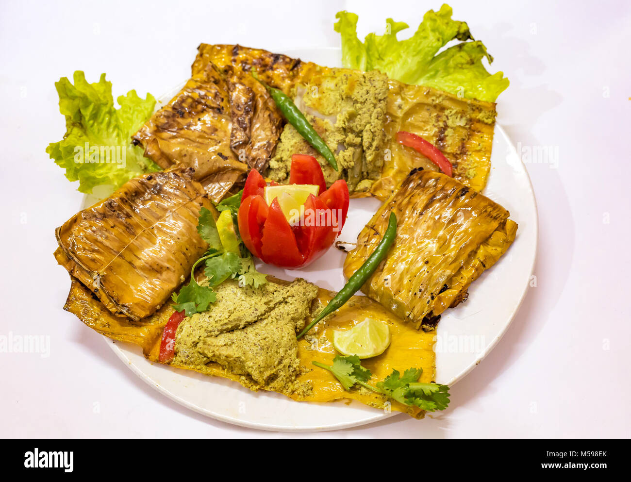 Spicy baked Indian fish cuisine made of Bhetki fish popularly known as Bhetki Paturi. A popular Bengali food. Stock Photo