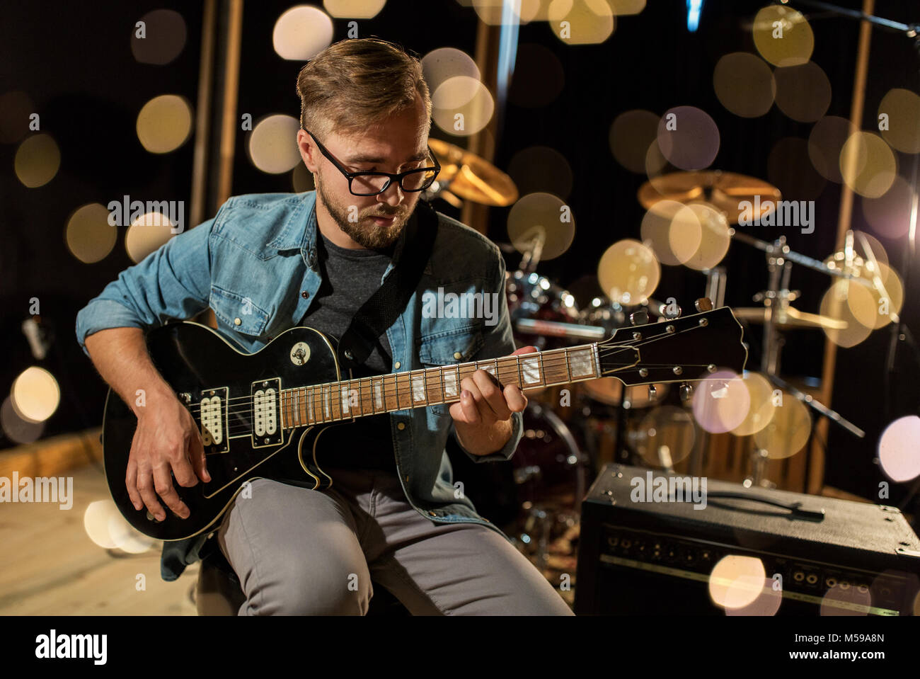 man playing guitar at studio rehearsal Stock Photo