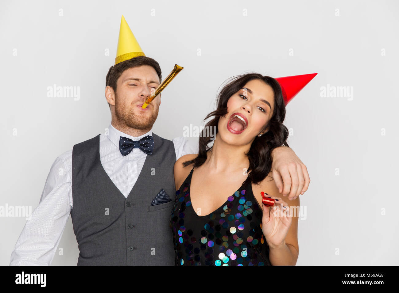 happy couple with party blowers having fun Stock Photo - Alamy