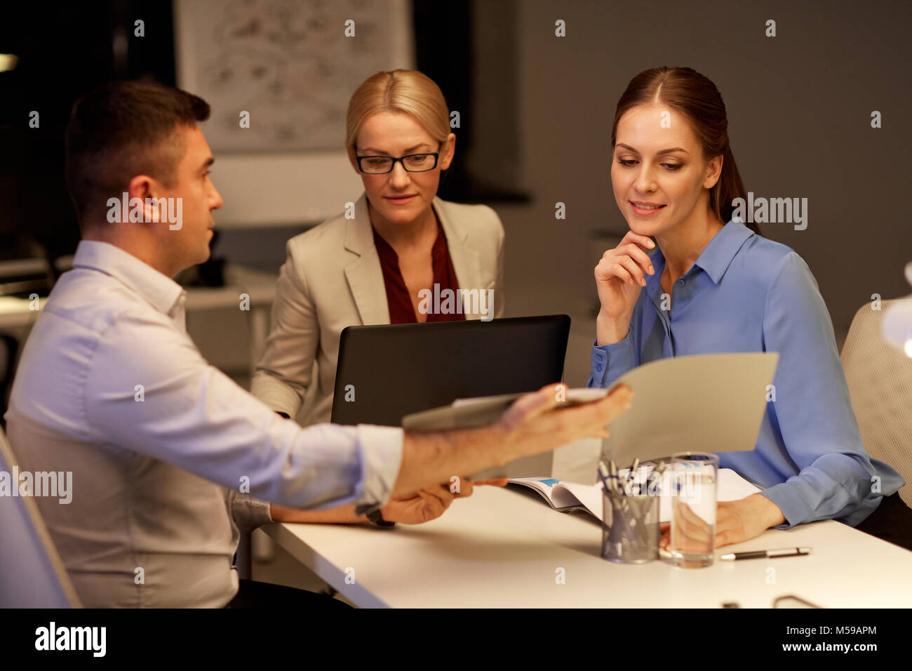 business team with papers working late at office Stock Photo Alamy