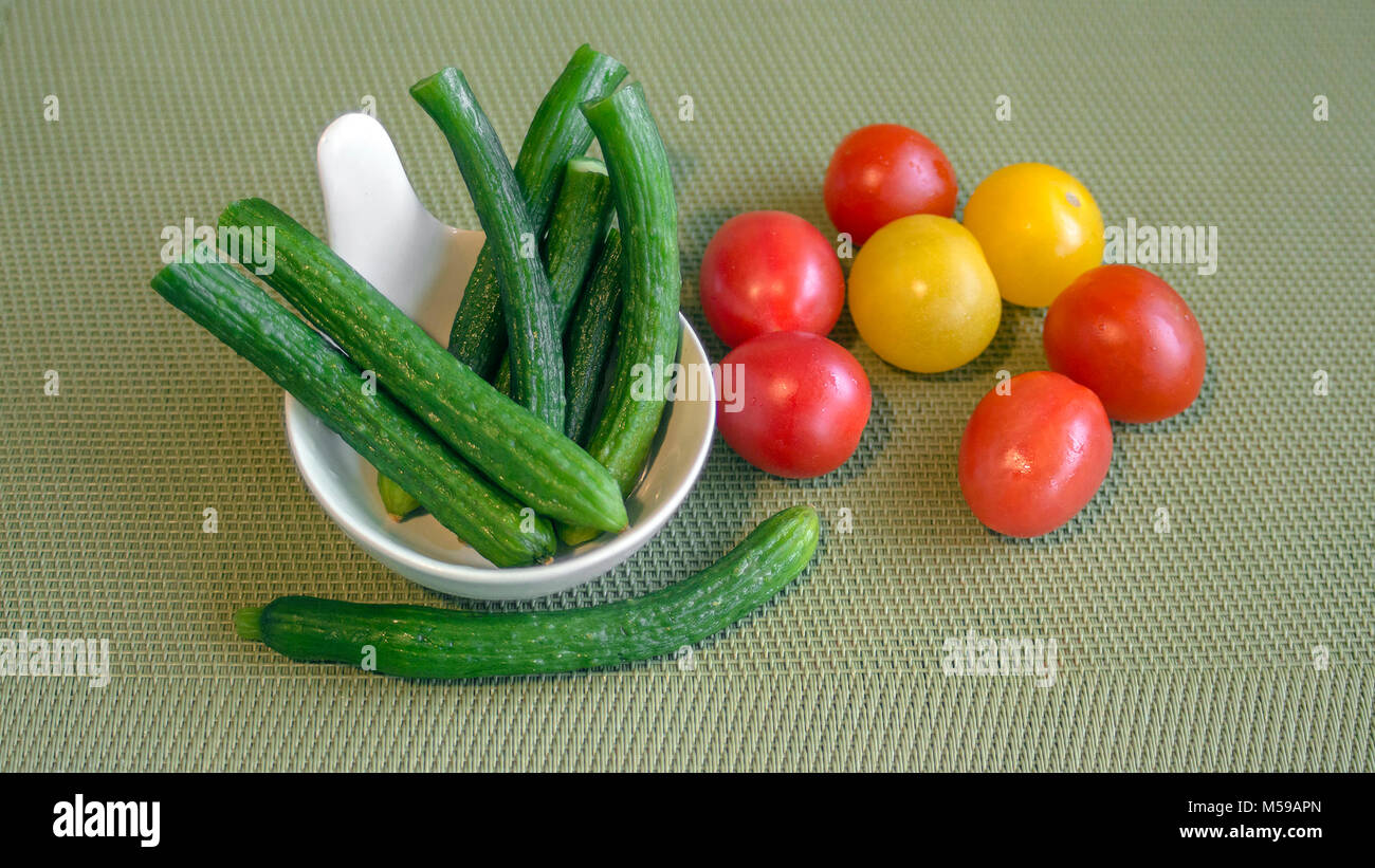 Still life of mini vegetables on a green background Stock Photo - Alamy