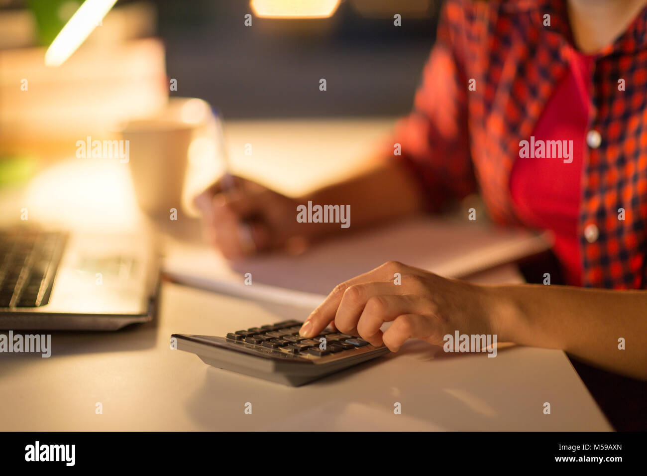 female student hand counting by calculator at home Stock Photo