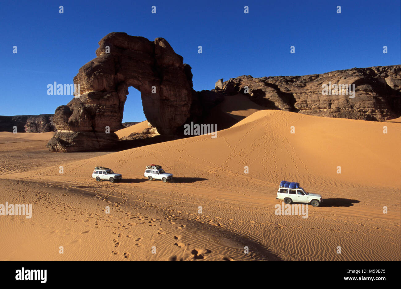 Libya. Near Ghat. Sahara desert. Akakus (Acacus) National Park. Natural arch called Fezzenger. 4x4 car. Stock Photo