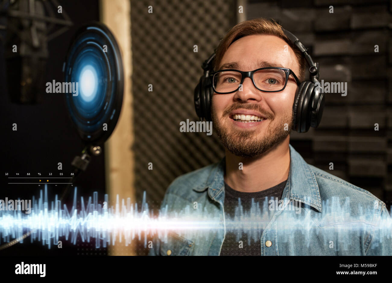 man with headphones singing at recording studio Stock Photo