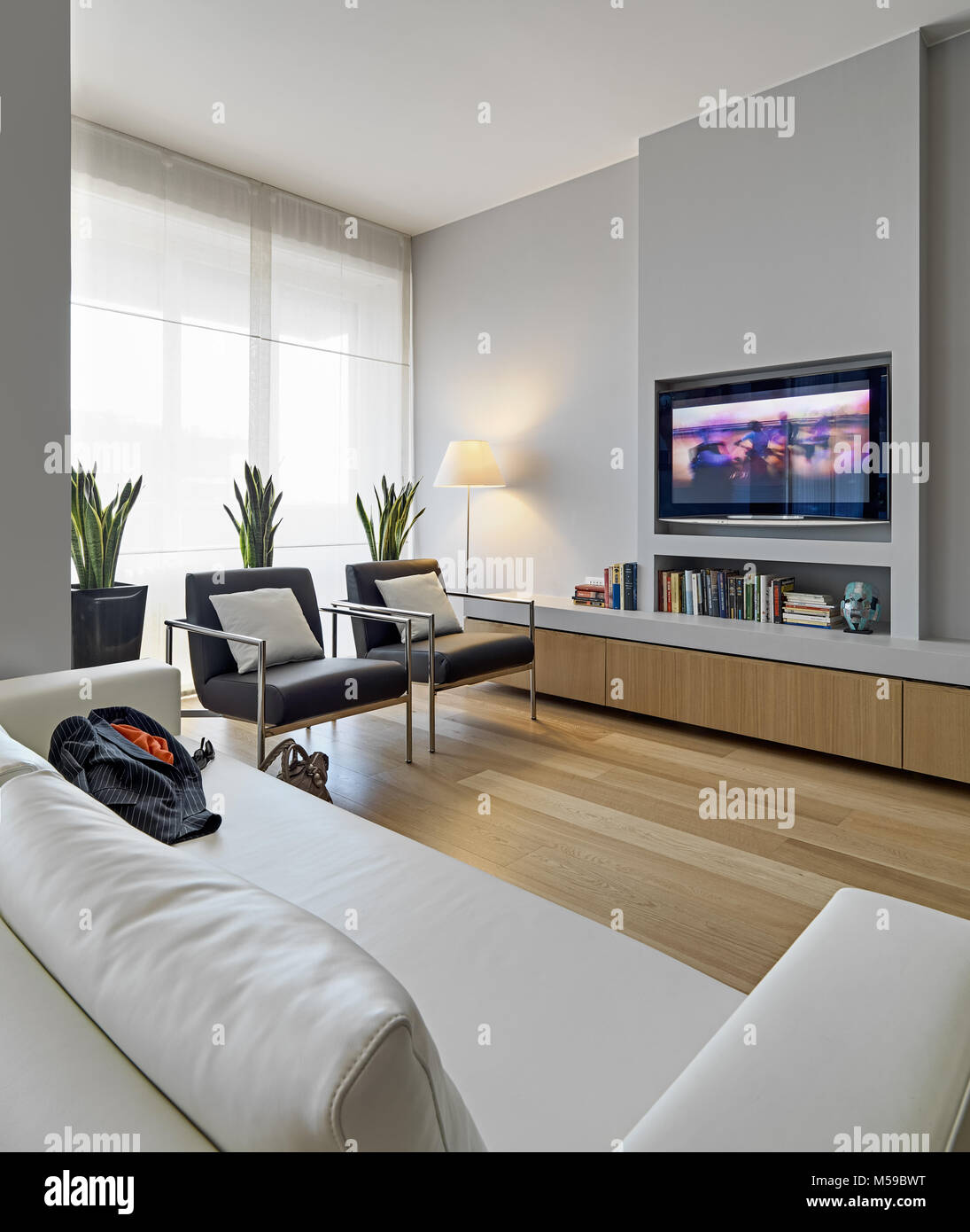 interiors shots of a modern living room in the foreground the beige leather sofa on the background two leather and iron armchairs, the floor is made o Stock Photo