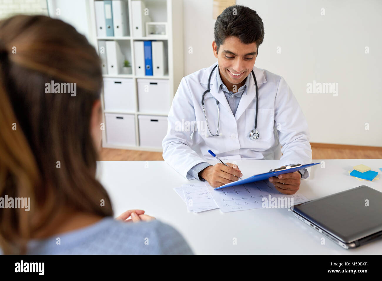 doctor with clipboard and patient at hospital Stock Photo - Alamy