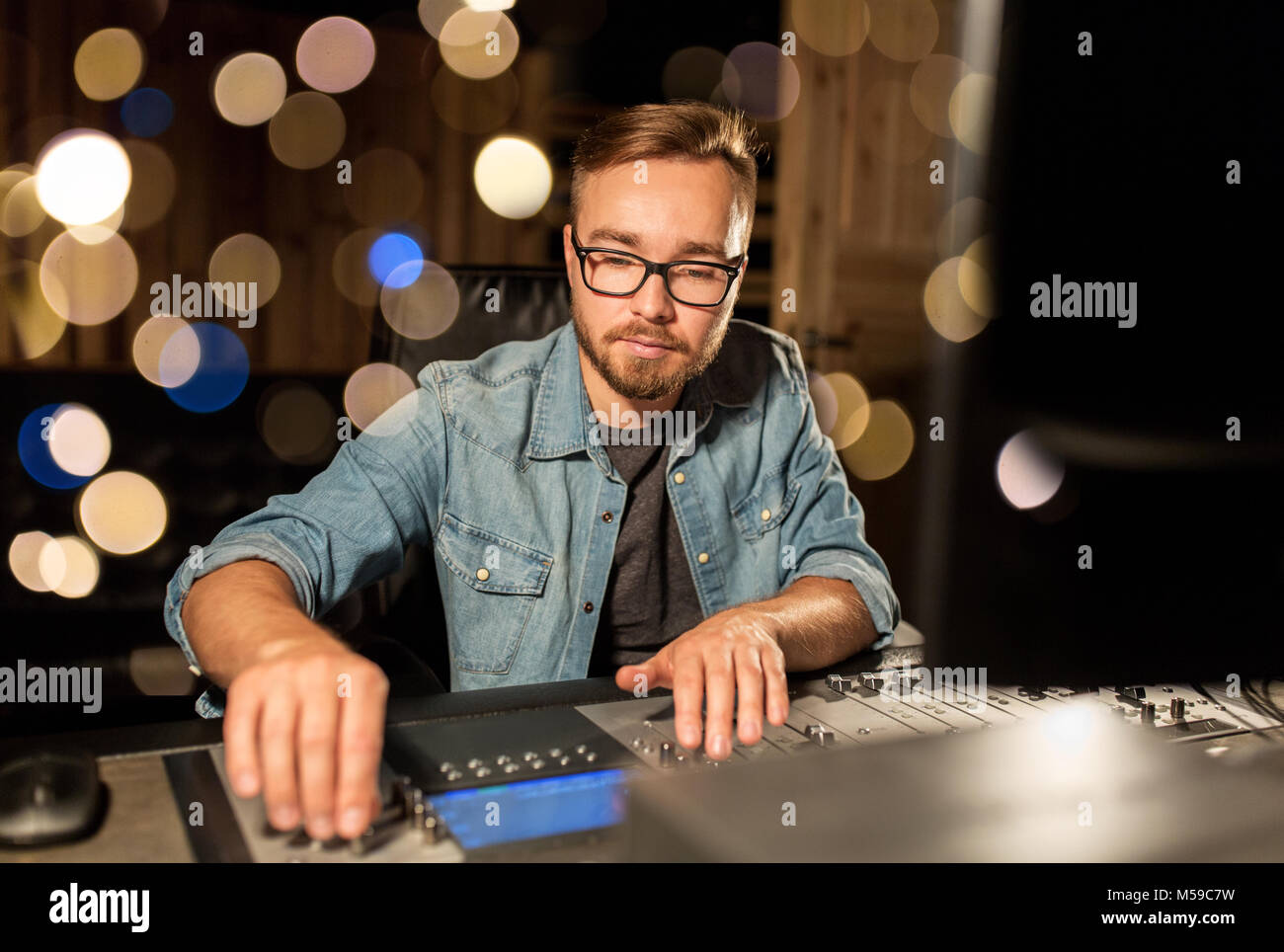 man at mixing console in music recording studio Stock Photo