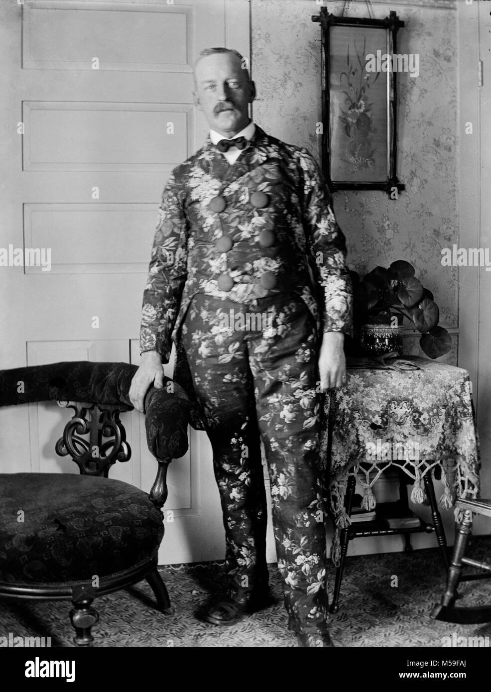 Turn of the 20th century man wears a really ugly flowered suit for a parlor portrait, ca. 1900. Stock Photo