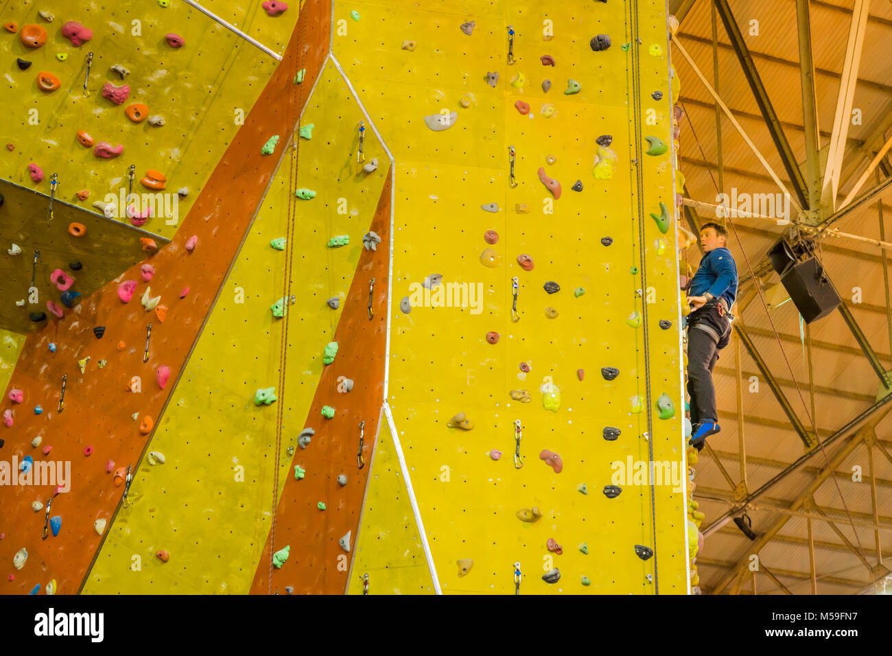 Man on a climbing wall inside of the Calshot Activities Centre, Calshot, UK Stock Photo