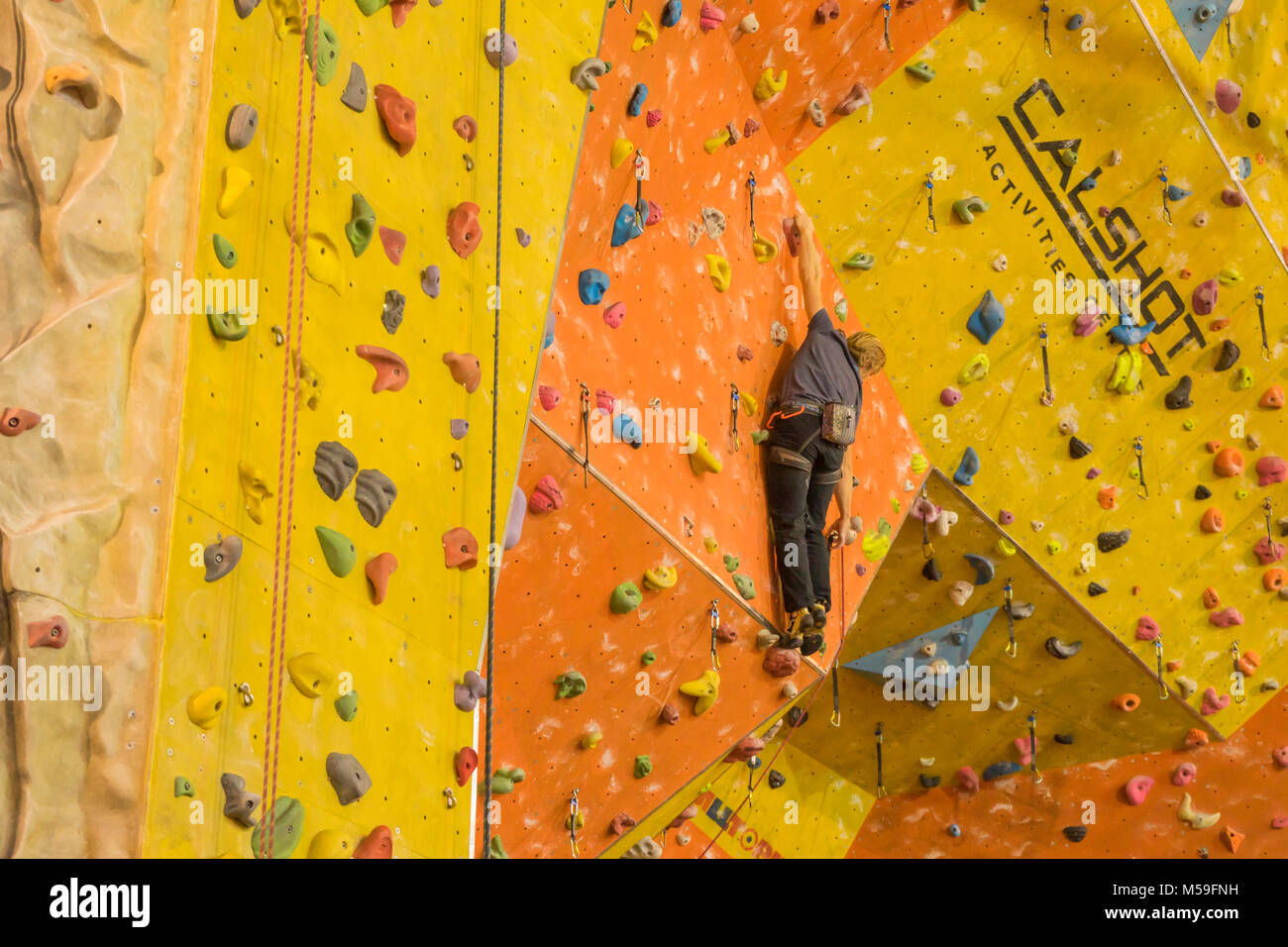 Man on a climbing wall inside Calshot Activities Centre, Calshot, UK Stock Photo