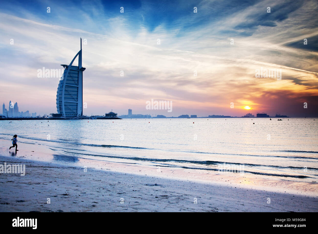 DUBAI, UAE - FEBRUARY 2018 :The world's first seven stars luxury hotel Burj Al Arab at sunset seen from Jumeirah public beach in Dubai, United Arab Em Stock Photo