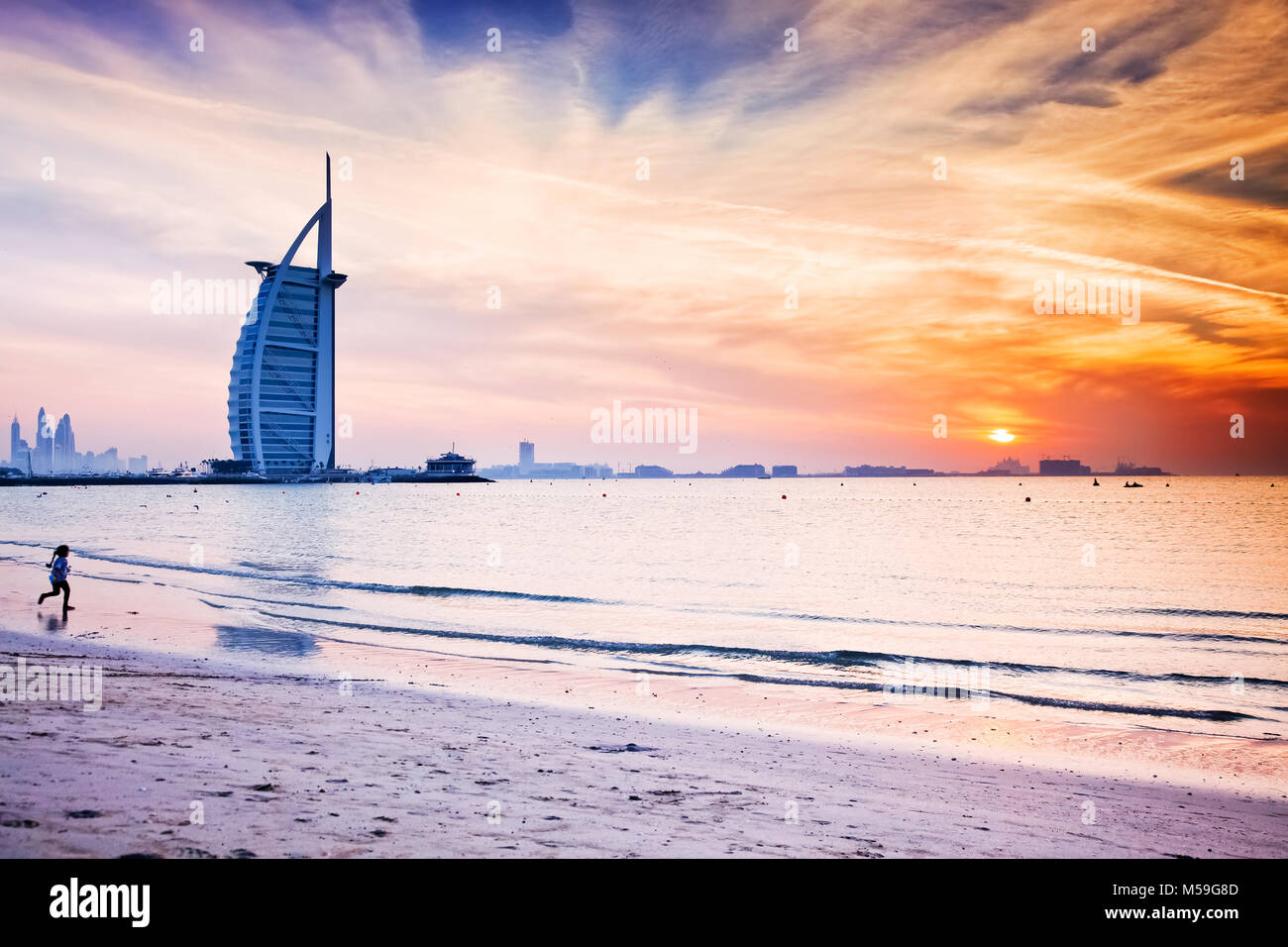 DUBAI, UAE - FEBRUARY 2018 :The world's first seven stars luxury hotel Burj Al Arab at sunset seen from Jumeirah public beach in Dubai, United Arab Em Stock Photo